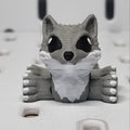 Gray bear-shaped object peeking out from a textured white surface